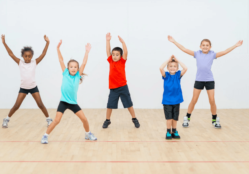 Kids doing jumping jacks during PE class